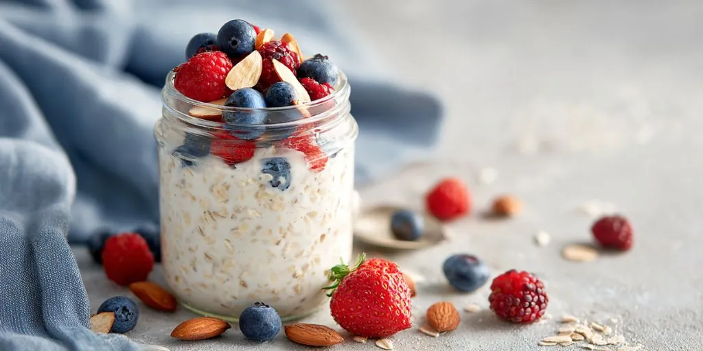 overnight oats in jar topped with strawberries blueberries raspberries and almonds